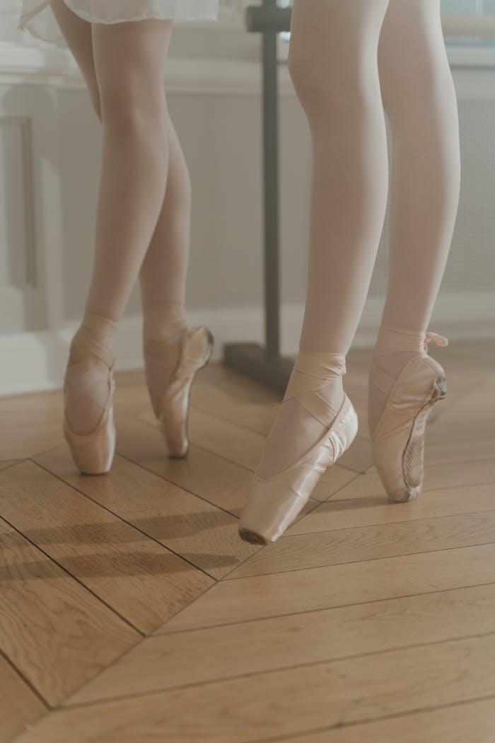 Ballet dancers in pointe shoes refining their technique in a serene dance studio.